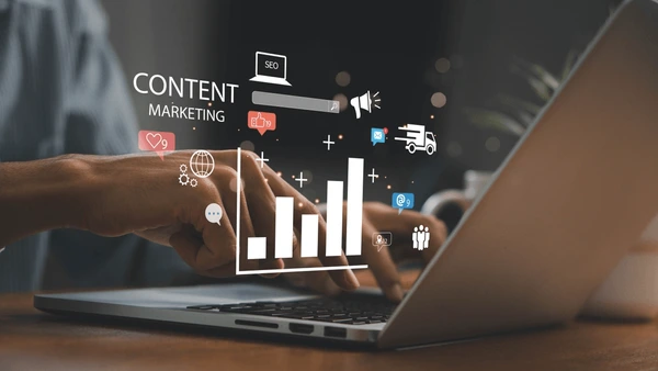 Hands typing on a laptop with glowing digital marketing icons, growth charts, and bold CONTENT MARKETING typography overlay.